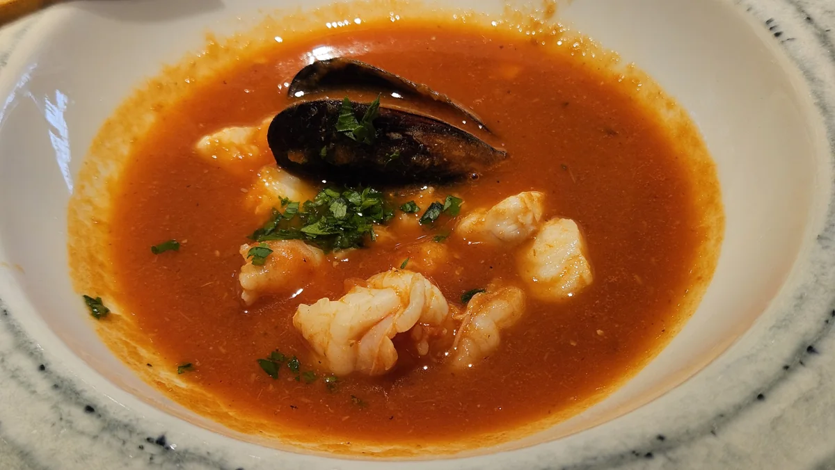 Bouillabaisse: Guiso marinero de pescado con azafrán, hinojo y un toque de naranja, acompañado de pan y rouille.