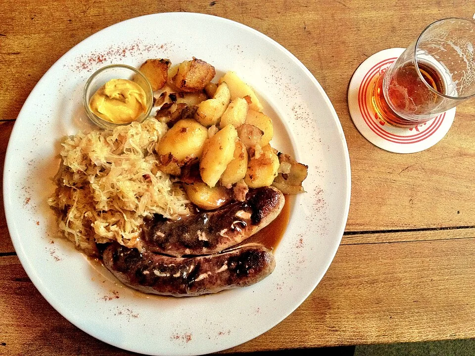 Bratwurst estilo Sheboygan: Salchicha de cerdo asada al carbón y servida en pan semmel con mostaza, cebolla y pepinillos, típica de las 'fry-outs' de Wisconsin.