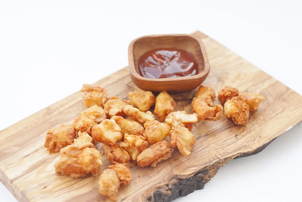 Cheese curds fritos de Wisconsin: Grumos de queso cheddar fresco rebozados y fritos, crujientes por fuera y elásticos y chirriantes por dentro.