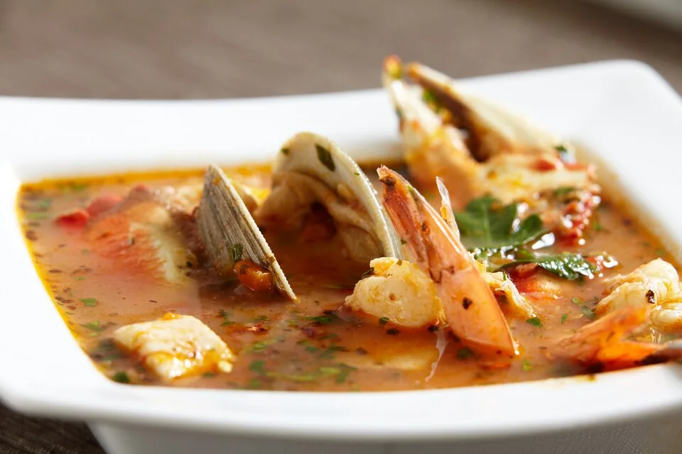 Cioppino: Guiso de mariscos en caldo de tomate y vino de los pescadores italianos de San Francisco, con cangrejo Dungeness, almejas, mejillones y pescado.