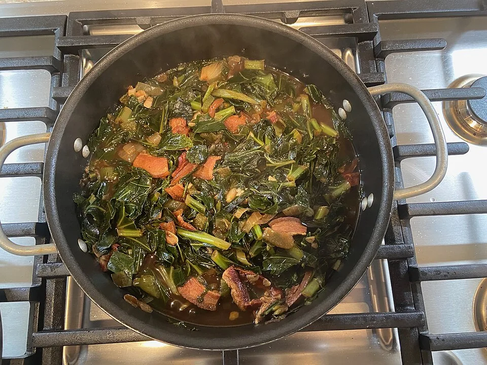 Collard greens: Hojas de berza cocidas lento con carne ahumada y su caldo especiado (potlikker), clásico del soul food.