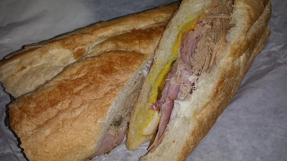 Cuban sandwich (Cubano): Sándwich prensado de pan cubano con cerdo asado, jamón, salami, queso suizo, mostaza y pepinillos.