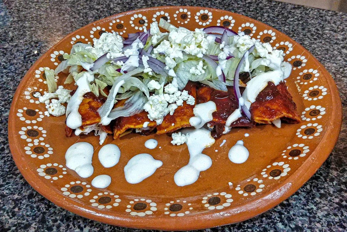 Enchiladas tultecas: Enchiladas de tortilla roja rellenas de queso y chorizo, coronadas con lechuga, jitomate y chile piquín.