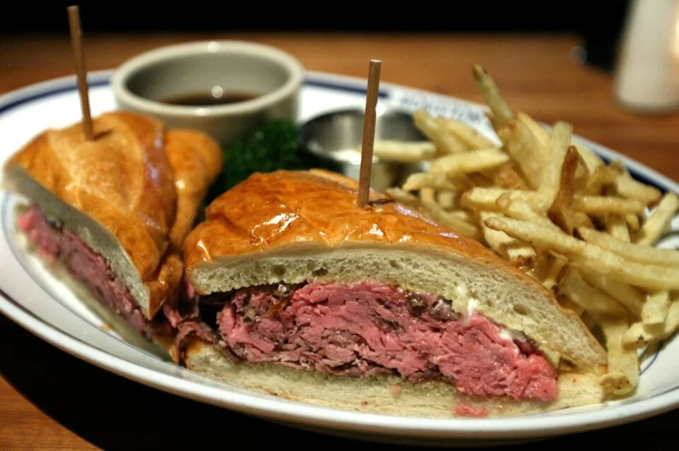 French dip: Sándwich de rosbif en pan francés servido con un tazón de jugo de carne (au jus) caliente para mojarlo.