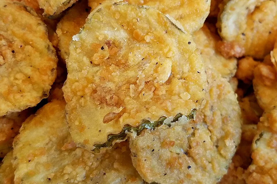 Fried pickles (pepinillos fritos): Rodajas de pepinillo rebozadas y fritas hasta quedar crujientes, servidas con salsa cremosa.
