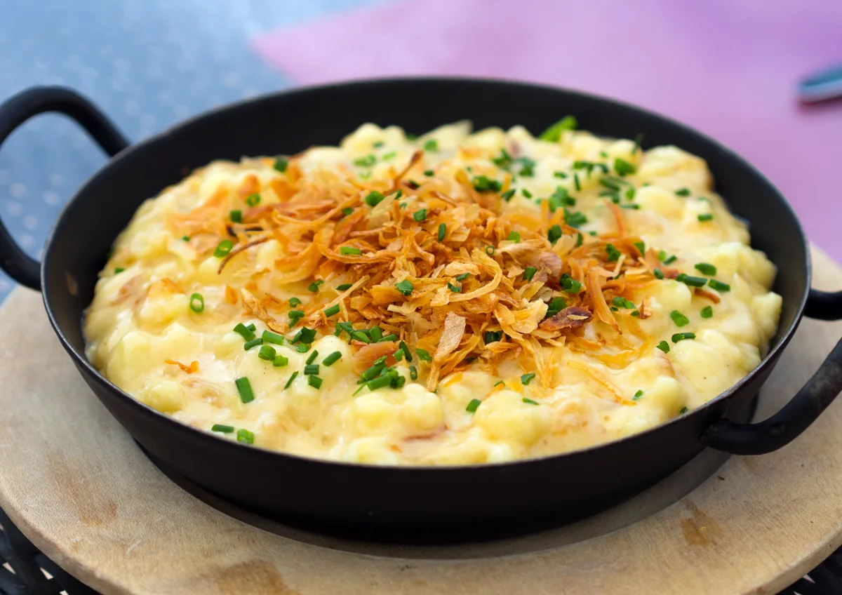 Käsespätzle: Pasta fresca de huevo mezclada con queso fundido y cebolla dorada.