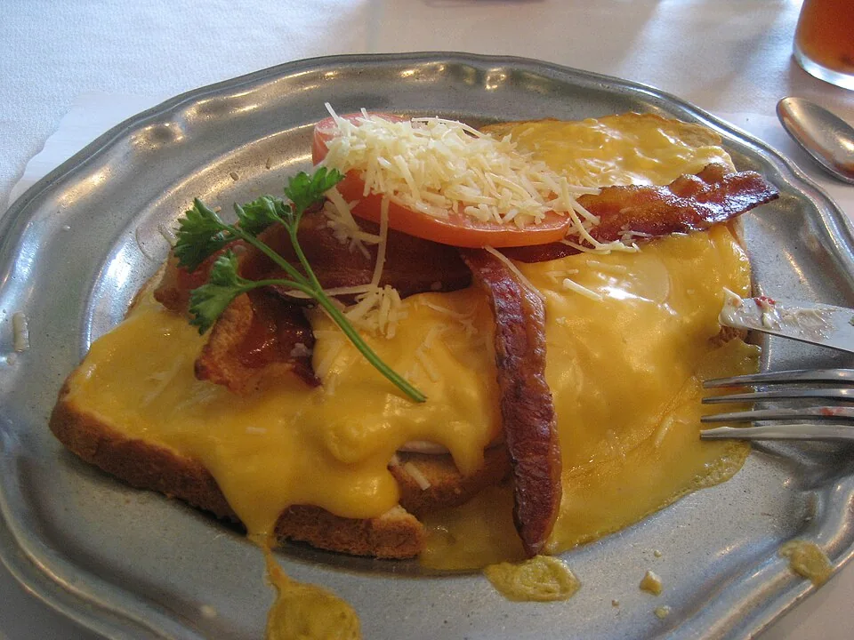 Kentucky Hot Brown: Emparedado abierto y gratinado de pavo con salsa Mornay, tocino y tomate, horneado hasta burbujear.