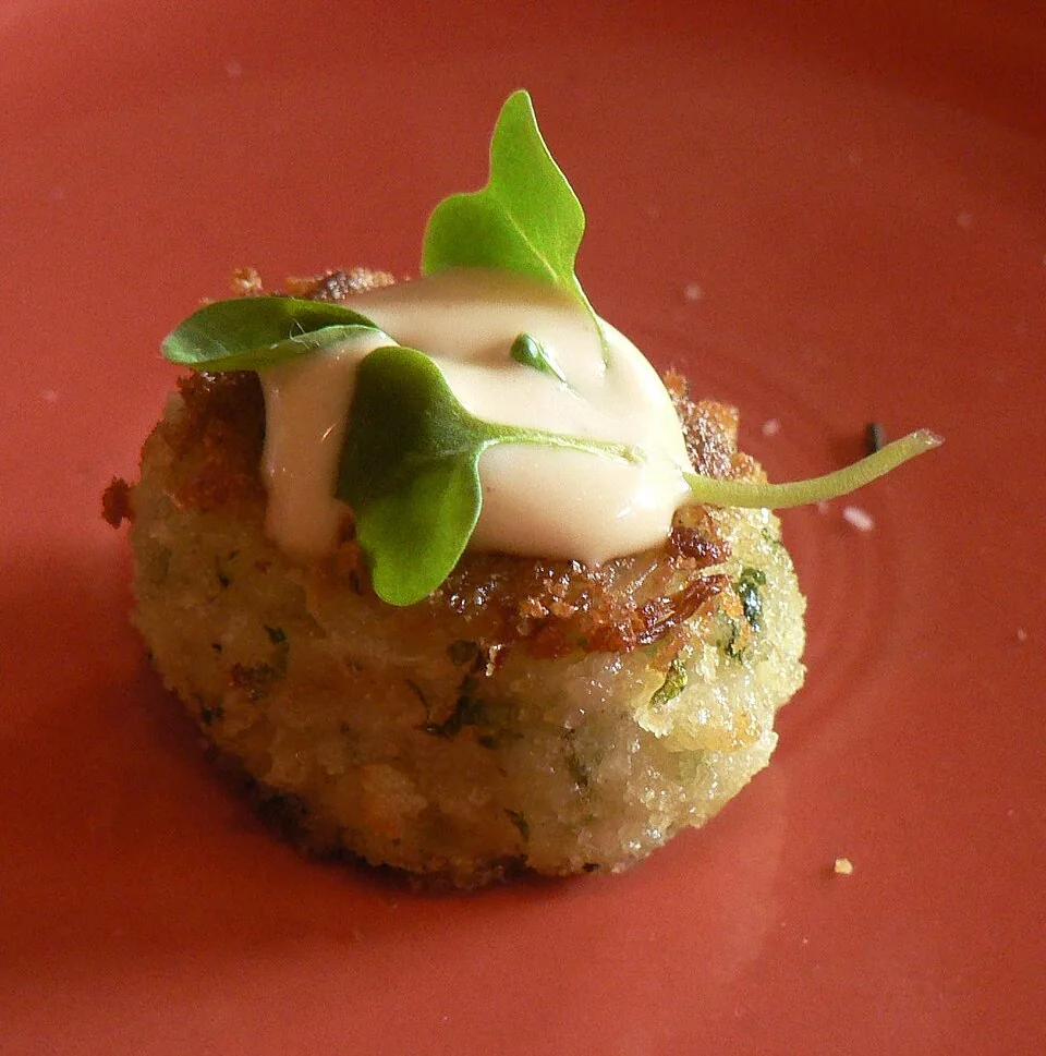 Maryland crab cakes: Tortitas de carne de cangrejo azul con muy poco relleno, sazonadas con Old Bay y doradas hasta quedar crujientes por fuera.