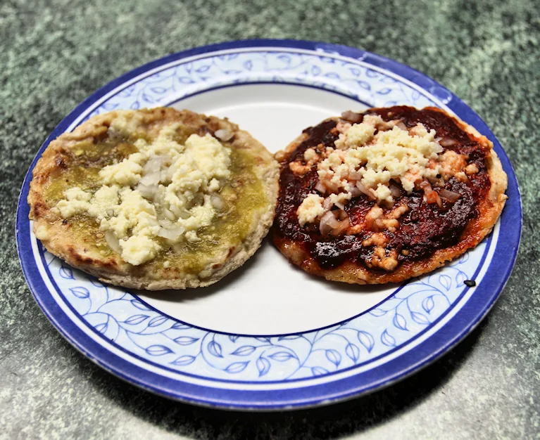 Memelas oaxaqueñas: Tortillas gruesas ovaladas con borde pellizcado, untadas de asiento, frijol y quesillo.