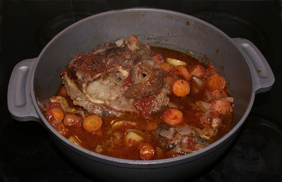 Ossobuco a la milanesa: Jarrete de ternera guisado lentamente con vino y verduras, terminado con gremolata de limón y perejil.