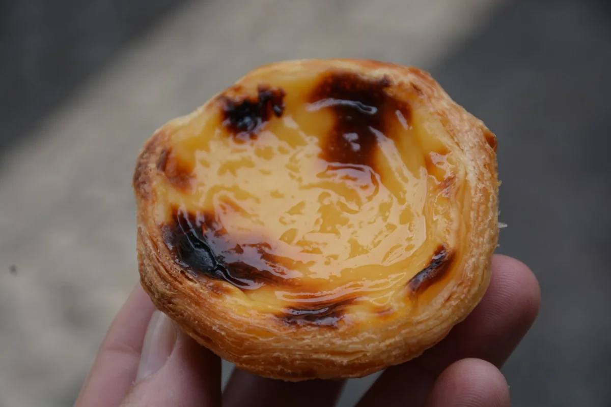 Pastéis de nata: Tartaletas portuguesas de hojaldre con crema de yema y superficie dorada.