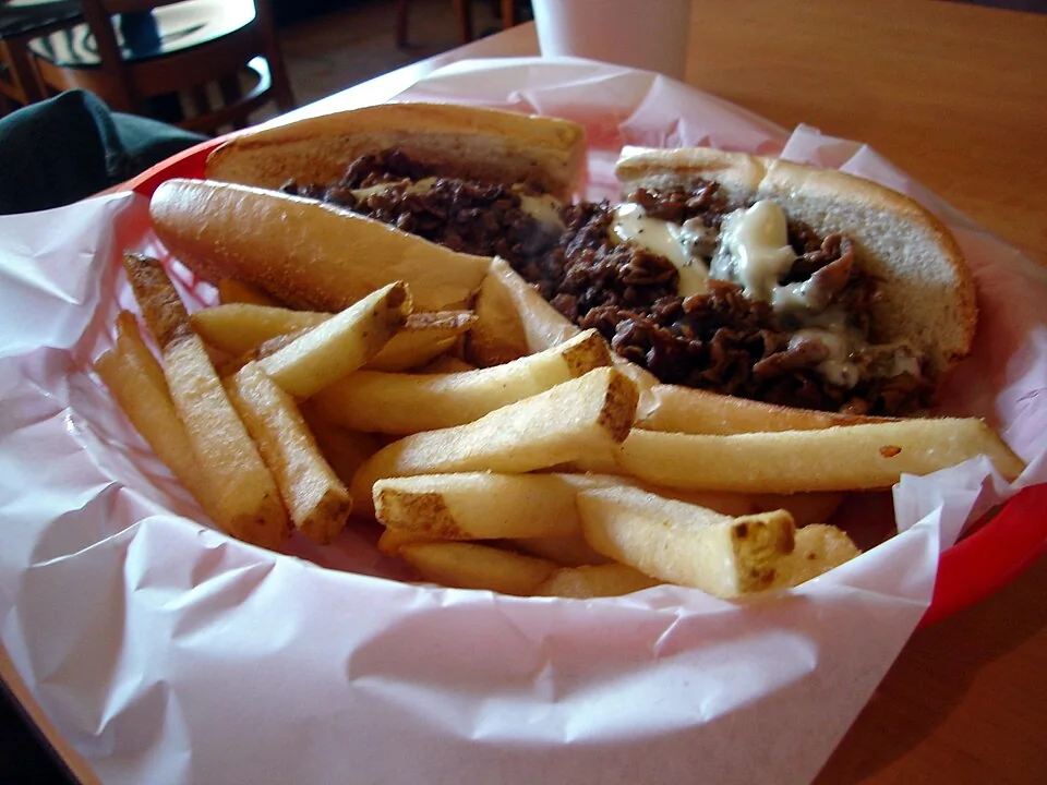 Philly cheesesteak: Bocadillo de tiras finas de res a la plancha con queso fundido en un pan largo, el sándwich insignia de Filadelfia.