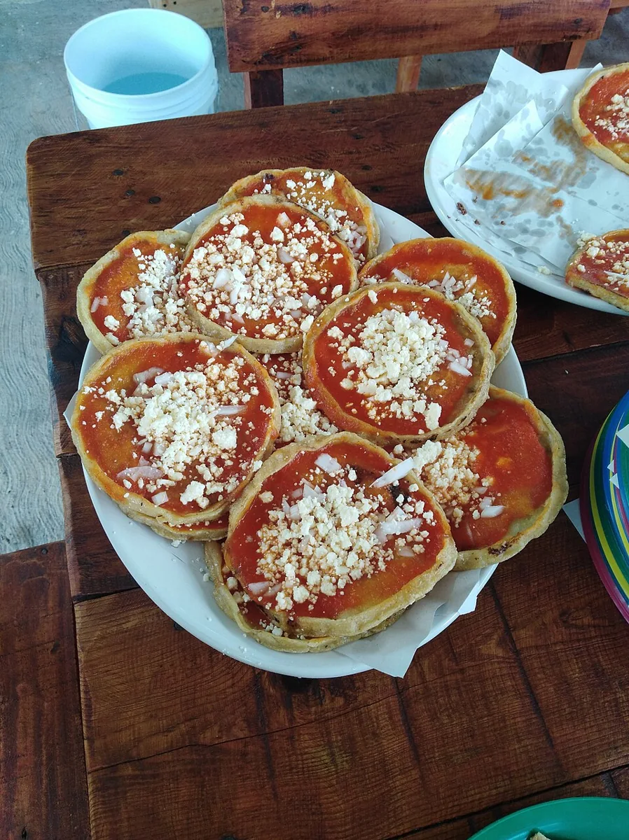 Picadas veracruzanas: Tortillas gruesas con borde pellizcado, salsa roja o verde, cebolla y queso fresco.