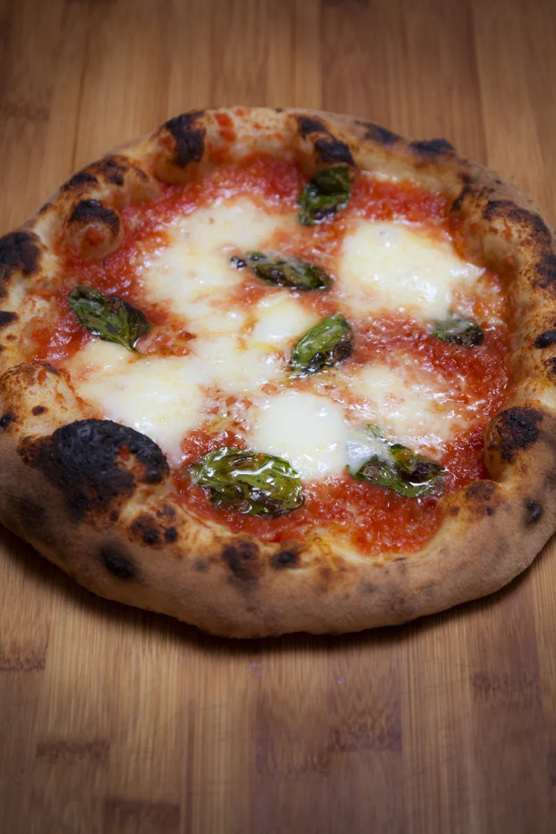 Pizza napolitana con mozzarella de búfala: Pizza de tomate, mozzarella de búfala y albahaca preparada con masa ya fermentada.