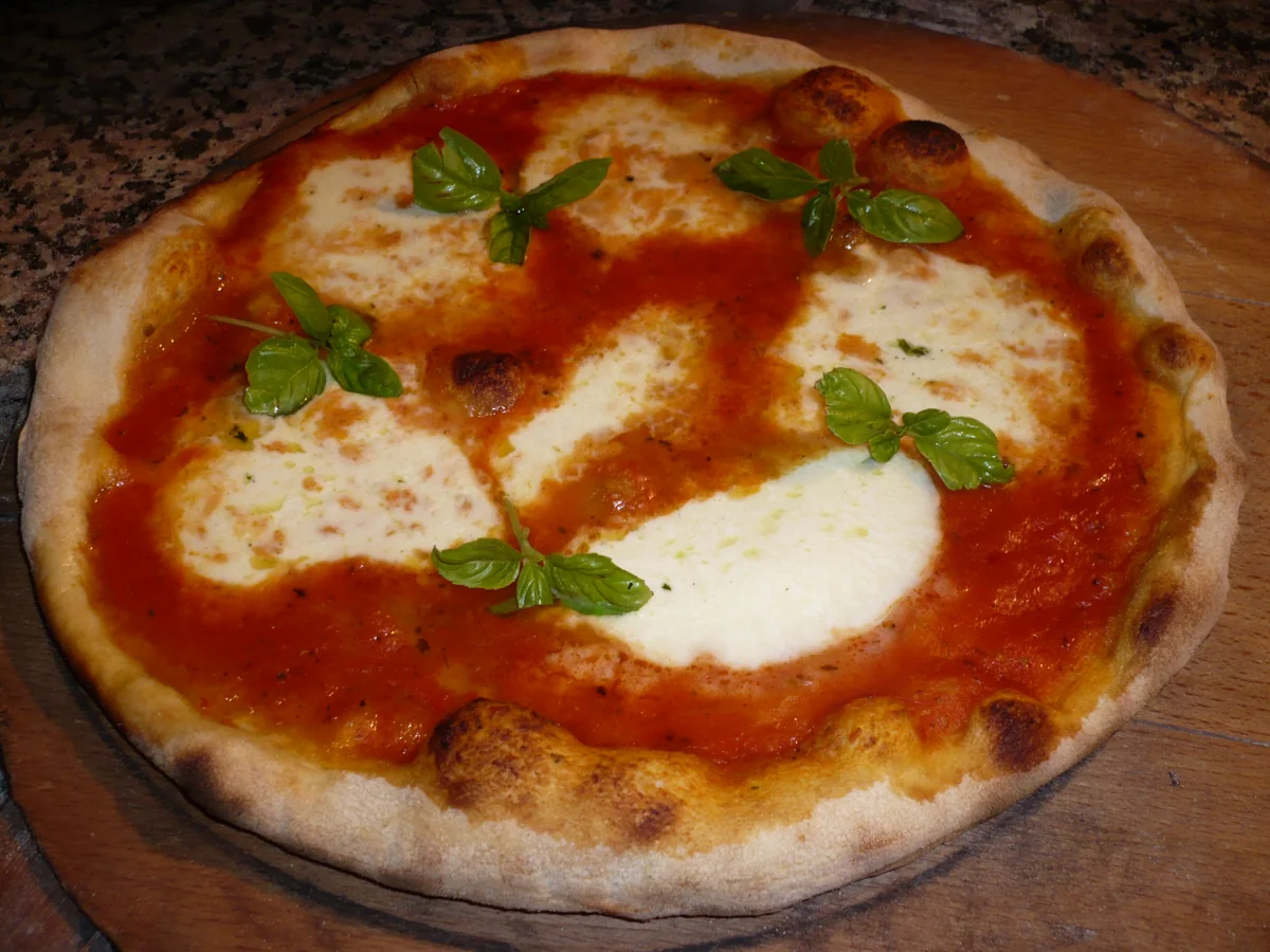 Pizza napolitana: Masa fina fermentada, tomate San Marzano, mozzarella y albahaca.