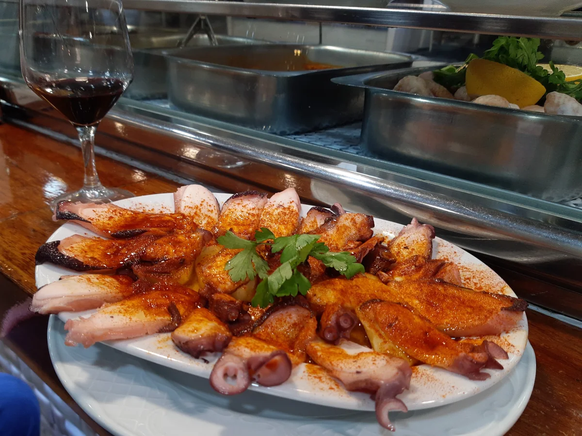 Pulpo a la gallega: Pulpo cocido hasta quedar tierno, servido con papa, pimentón, aceite de oliva y sal gruesa.