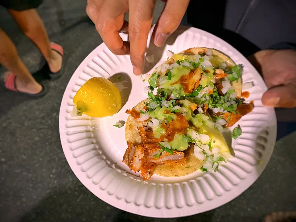 Tacos al pastor: Cerdo adobado al trompo con piña, cebolla y cilantro.