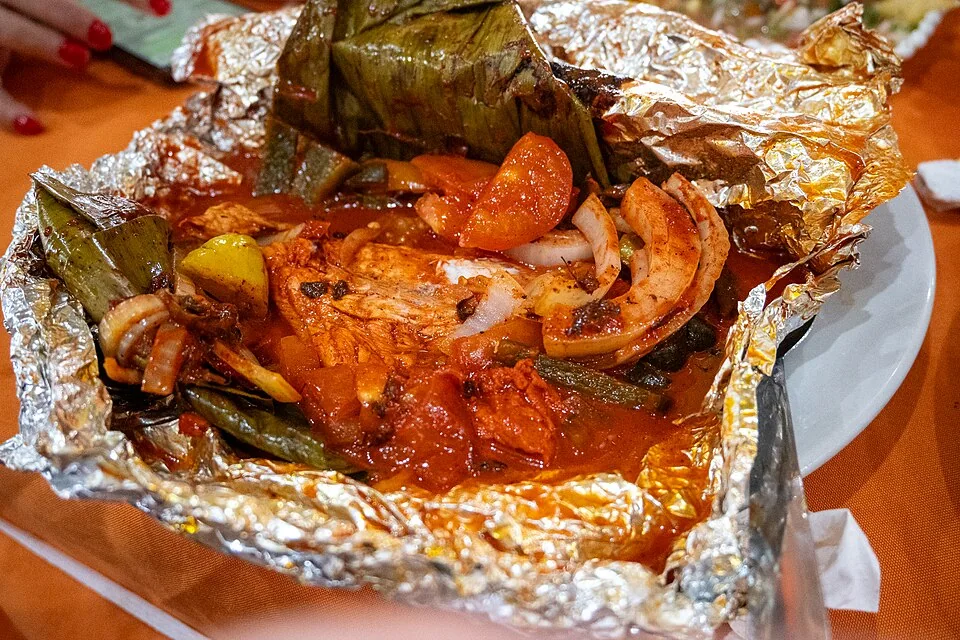 Tikin xic: Pescado marinado en recado de achiote y naranja agria, envuelto en hoja de plátano y asado.