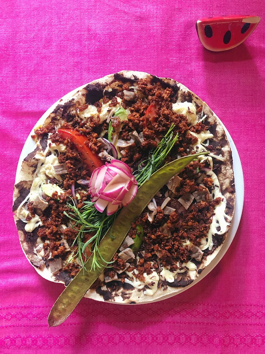 Tlayudas oaxaqueñas: Tortilla grande y crujiente con asiento, frijol, quesillo y tasajo.