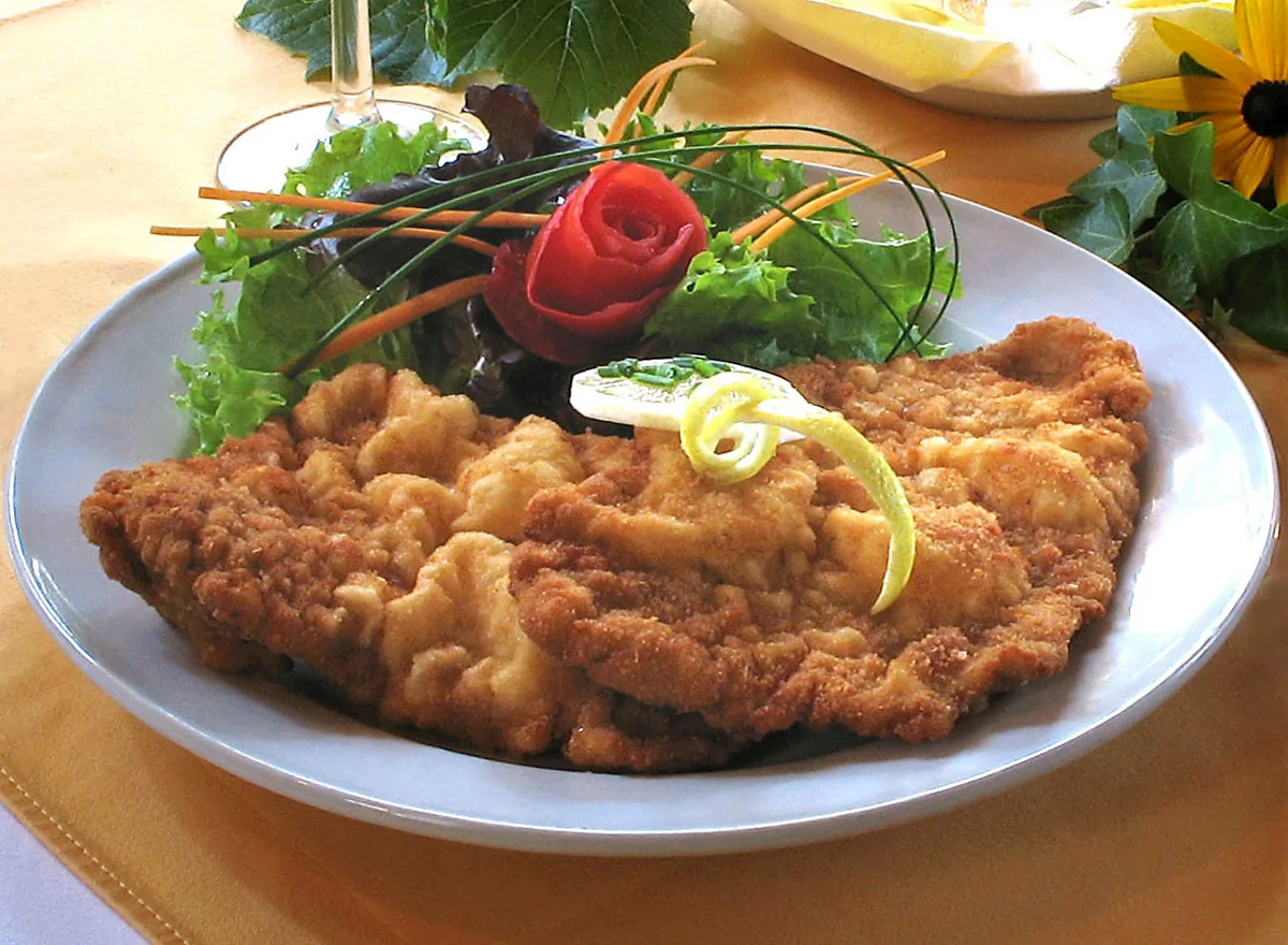 Wiener Schnitzel: Filete fino de ternera empanizado y frito, con una cubierta ligera y crujiente.